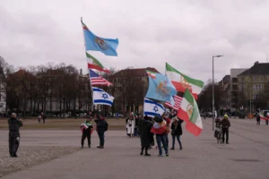Theresienwiese’de Münih Güvenlik Konferansı sırasında İran protestosuna katılan göstericiler farklı bayraklar taşıyor.
