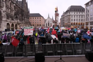 Marienplatz meydanında yağmur altında toplanan kalabalık.